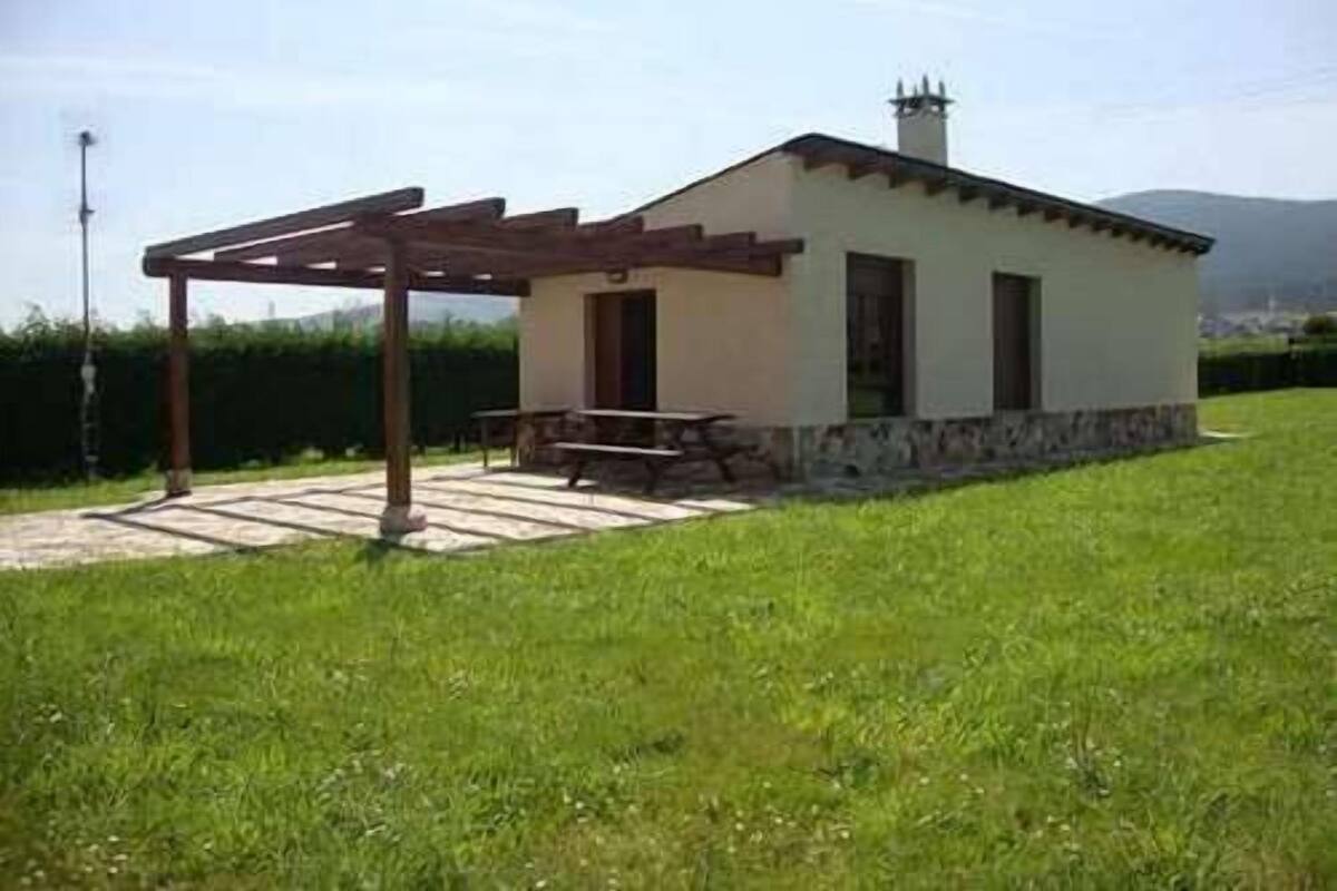 A small, single-story house with a patio area and a pergola.