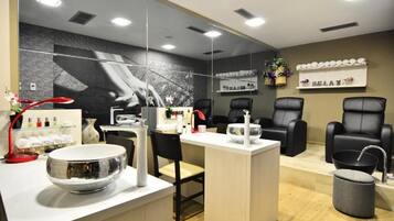 Un moderno spa con recepción, zona de estar y un espejo grande.