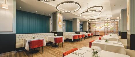 A restaurant with multiple tables, booths, and a decorative ceiling.