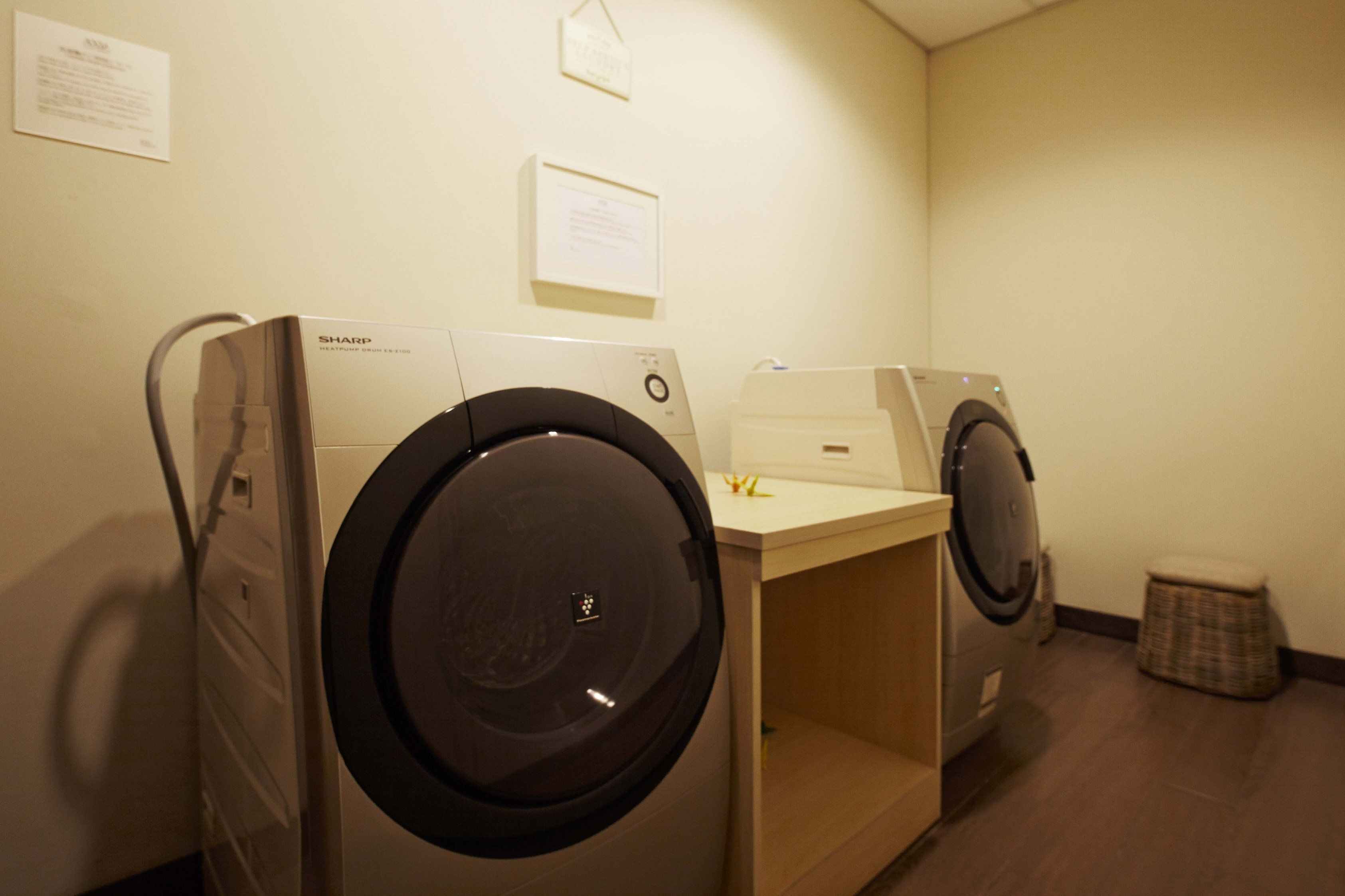Une buanderie équipée de deux machines à laver à chargement frontal et d’un sèche-linge.