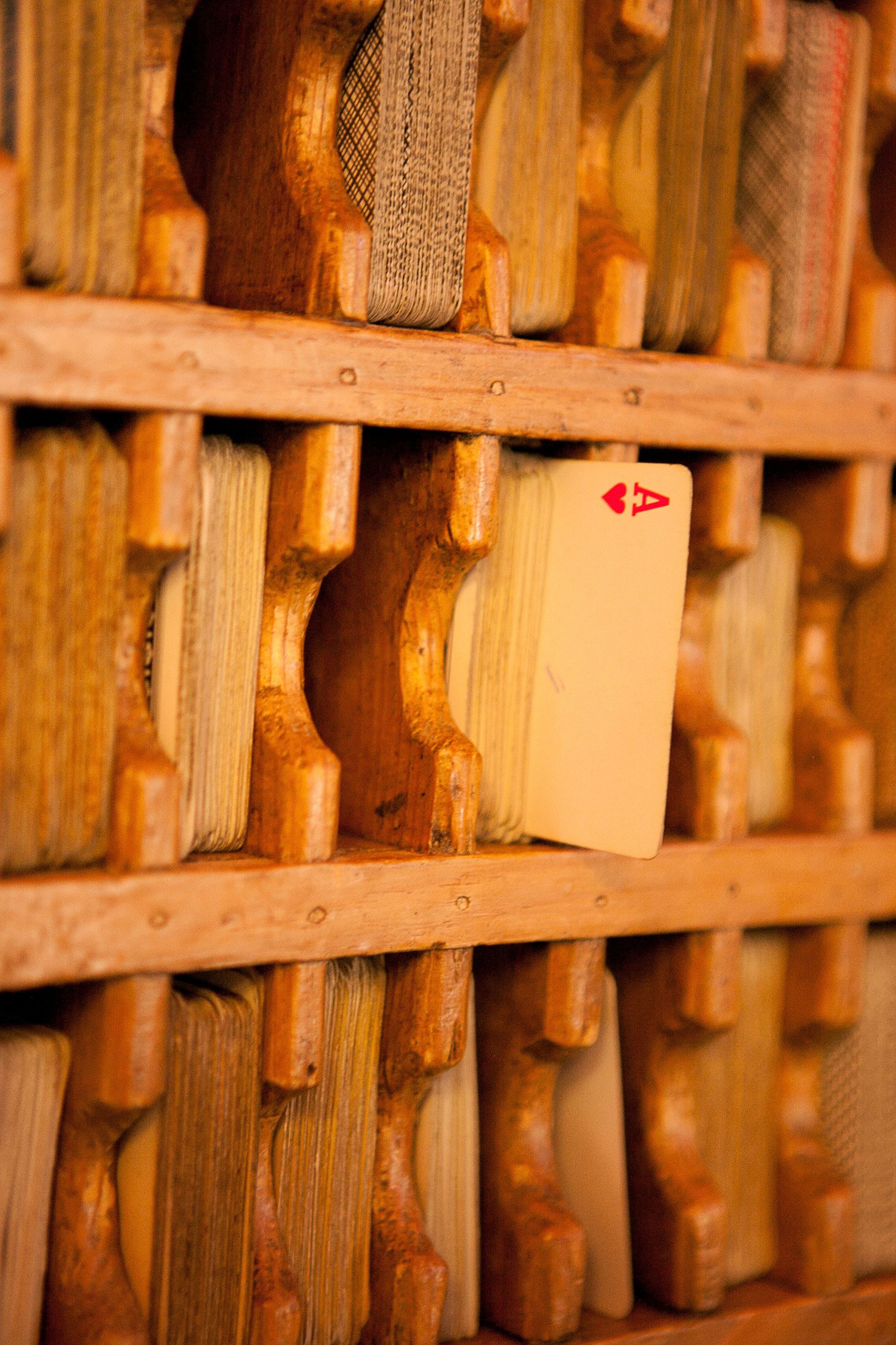 A wooden rack with a playing card inserted into it.