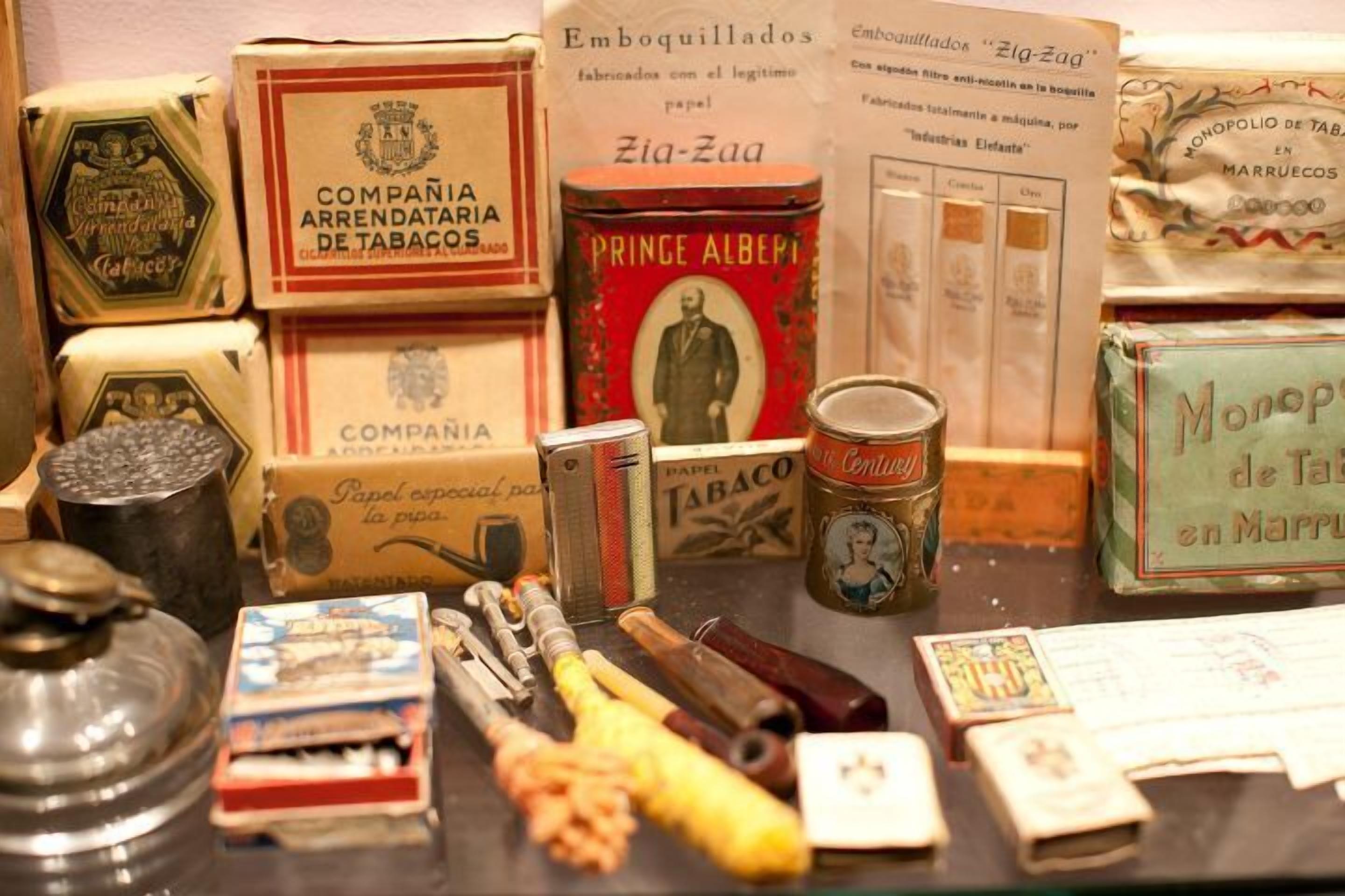 A display of vintage tobacco products including boxes, tins, and smoking accessories.