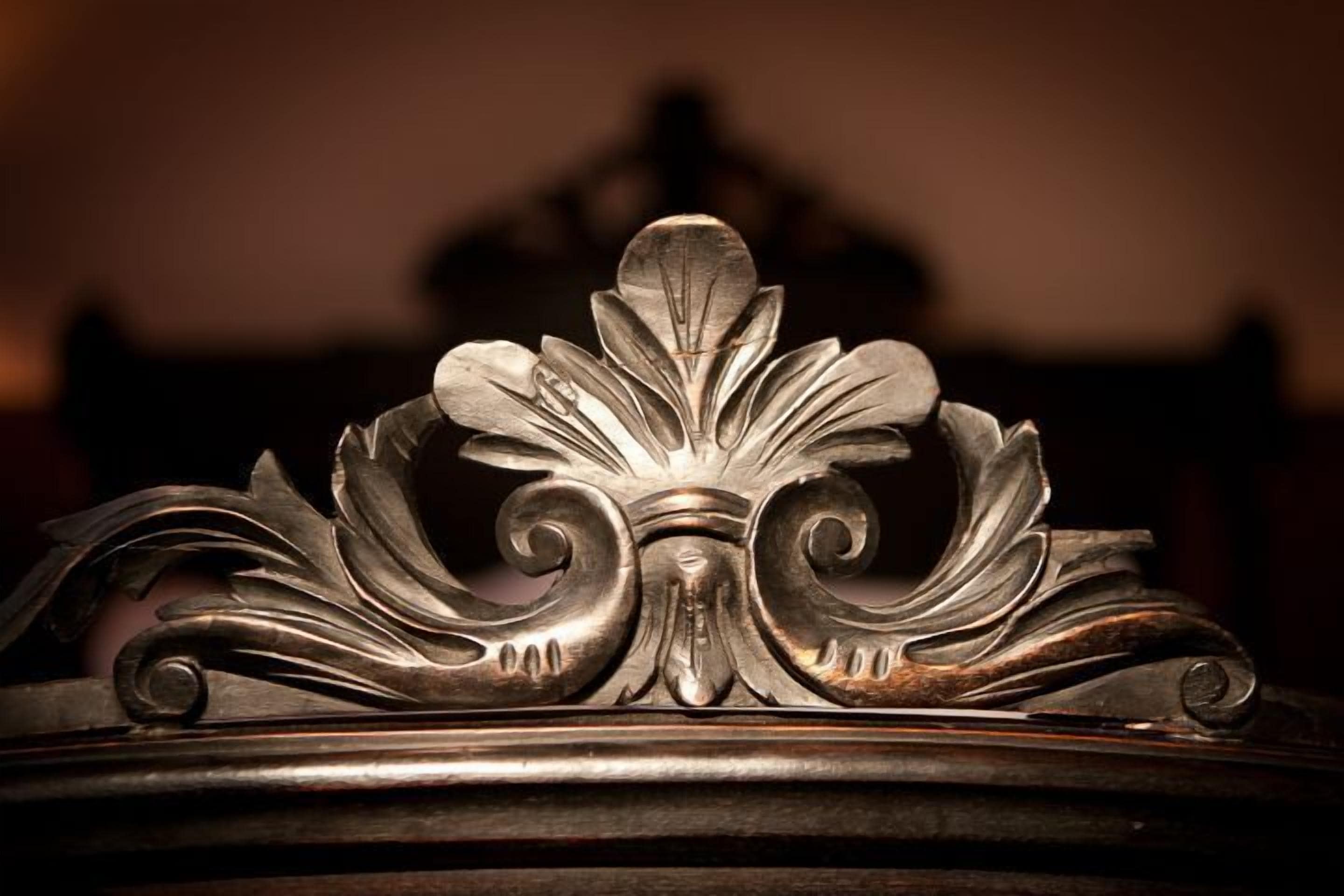 A close-up of an ornate metal design, likely part of a piece of furniture or architectural detail.