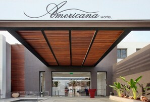 The entrance of Americana Hotel with a modern design, featuring a wooden ceiling and glass doors. - Americana Hotel (Eilat)