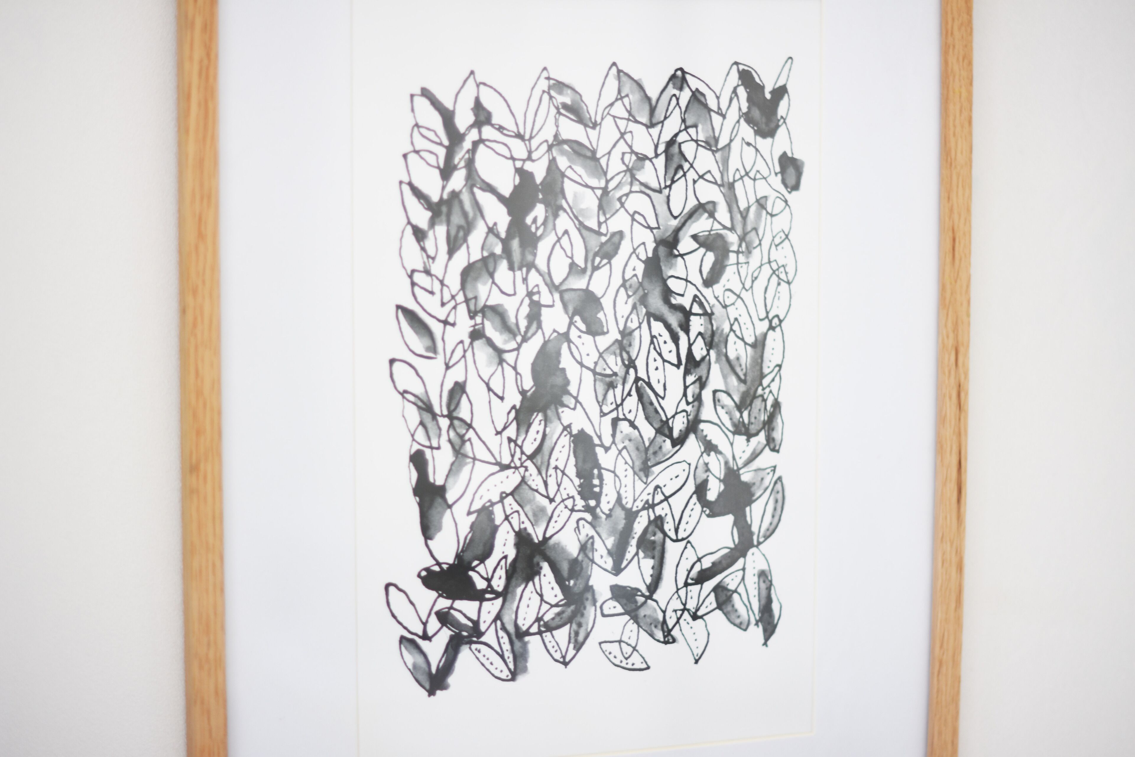 Una obra d'art abstracta emmarcada amb un dibuix dens de formes negres i blanques.