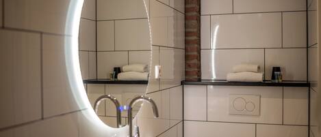 Un baño moderno con un espejo grande, un lavabo y un perchero para toallas.