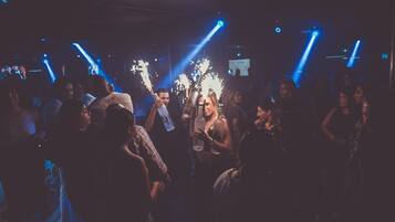 A crowded indoor space with people holding illuminated objects, suggesting a social event or party.