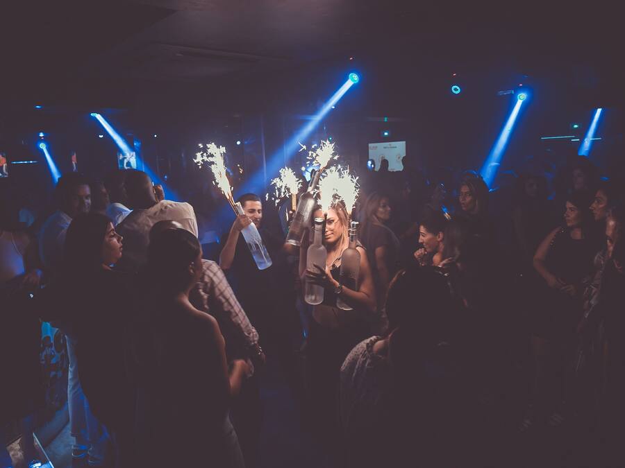 A crowded indoor space with people holding illuminated objects, suggesting a social event or party.