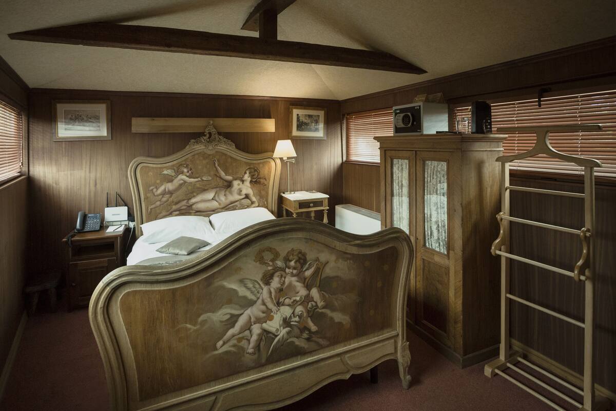 Un dormitorio con una cama grande, una mesita de noche, un aparador y un armario.