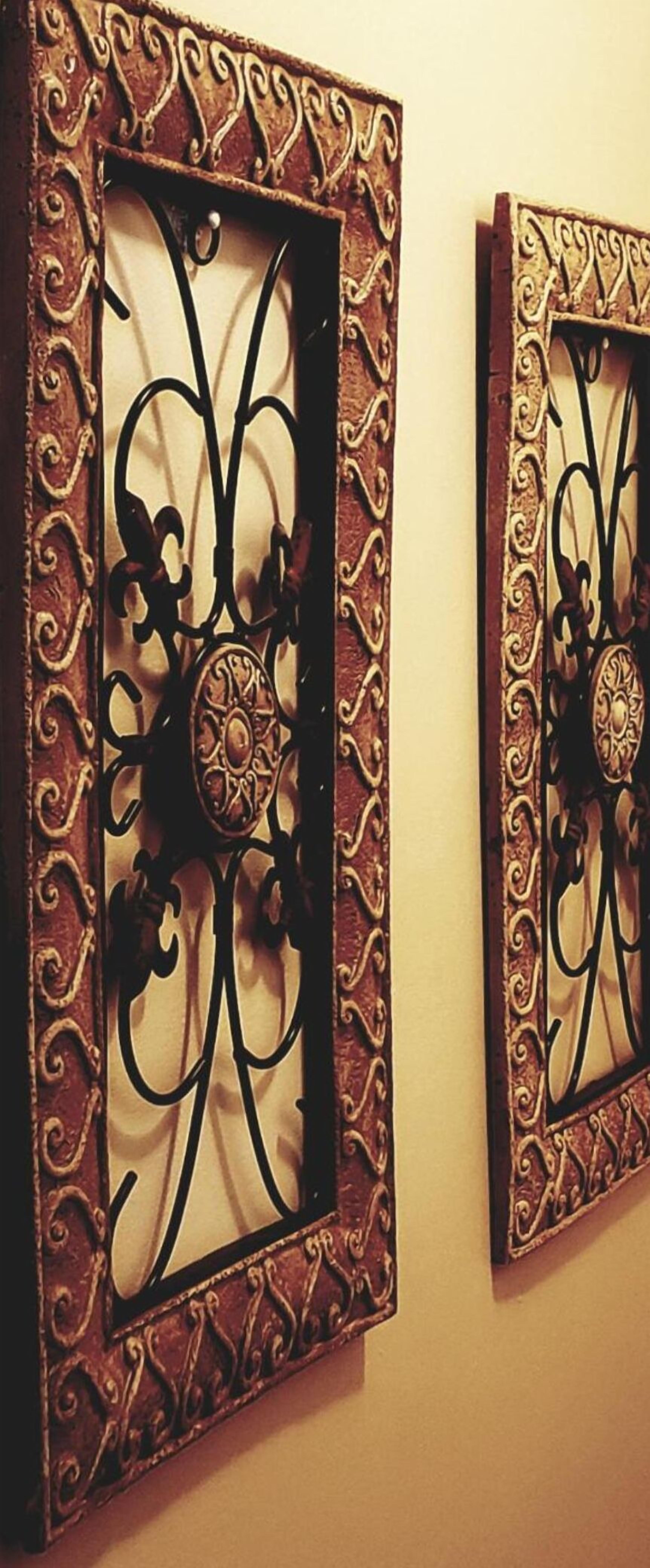 Two wall-mounted decorative metal panels with intricate designs and a central circular motif.
