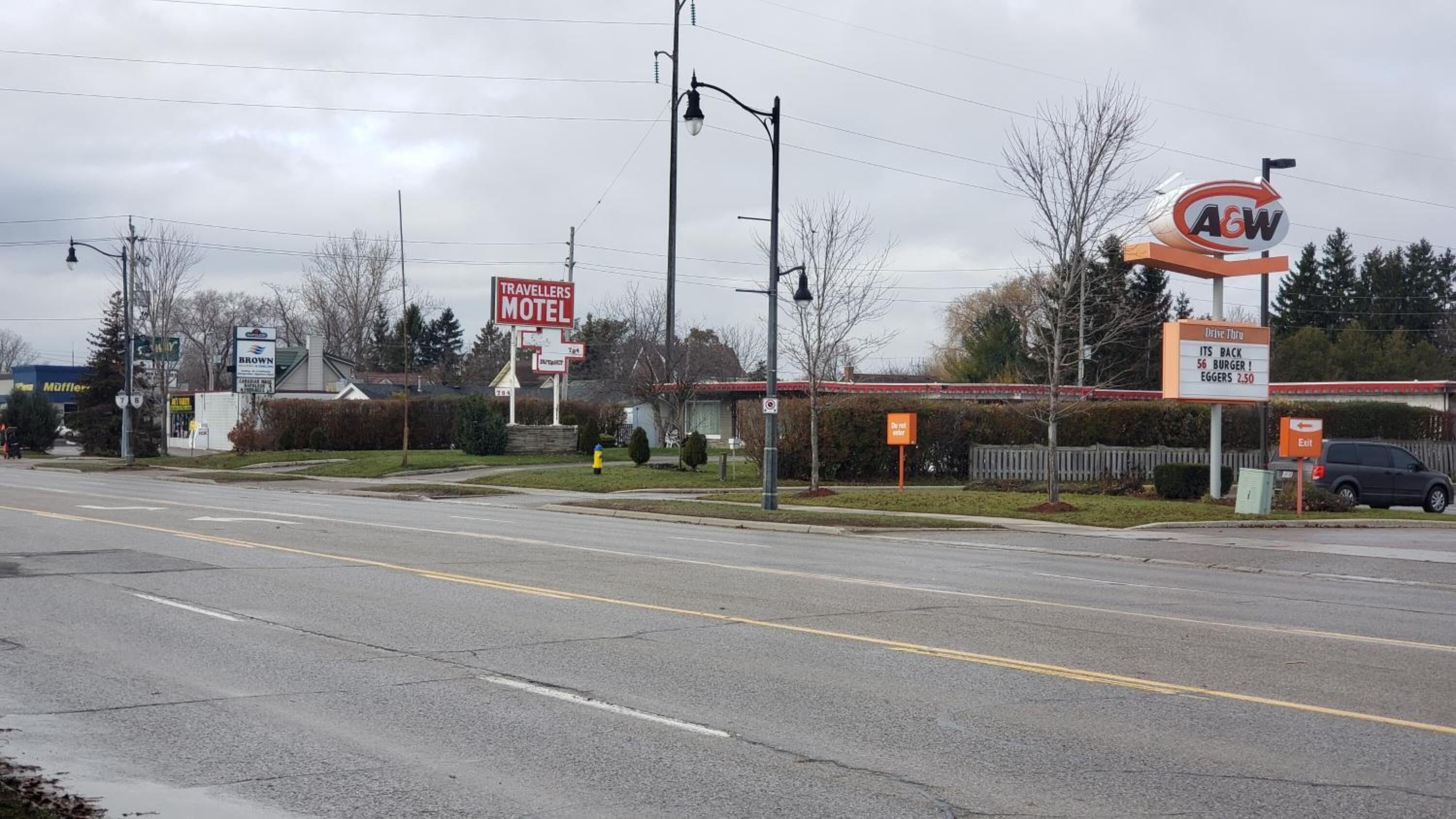 Un motel con insegna, accesso diretto in auto e un ristorante A&W nelle vicinanze.
