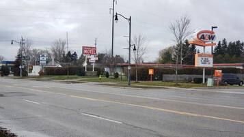 Un motel con insegna, accesso diretto in auto e un ristorante A&W nelle vicinanze.