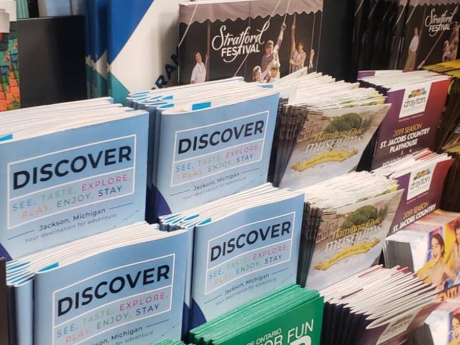 Une exposition de guides de voyage et de cartes de différentes destinations du Michigan.