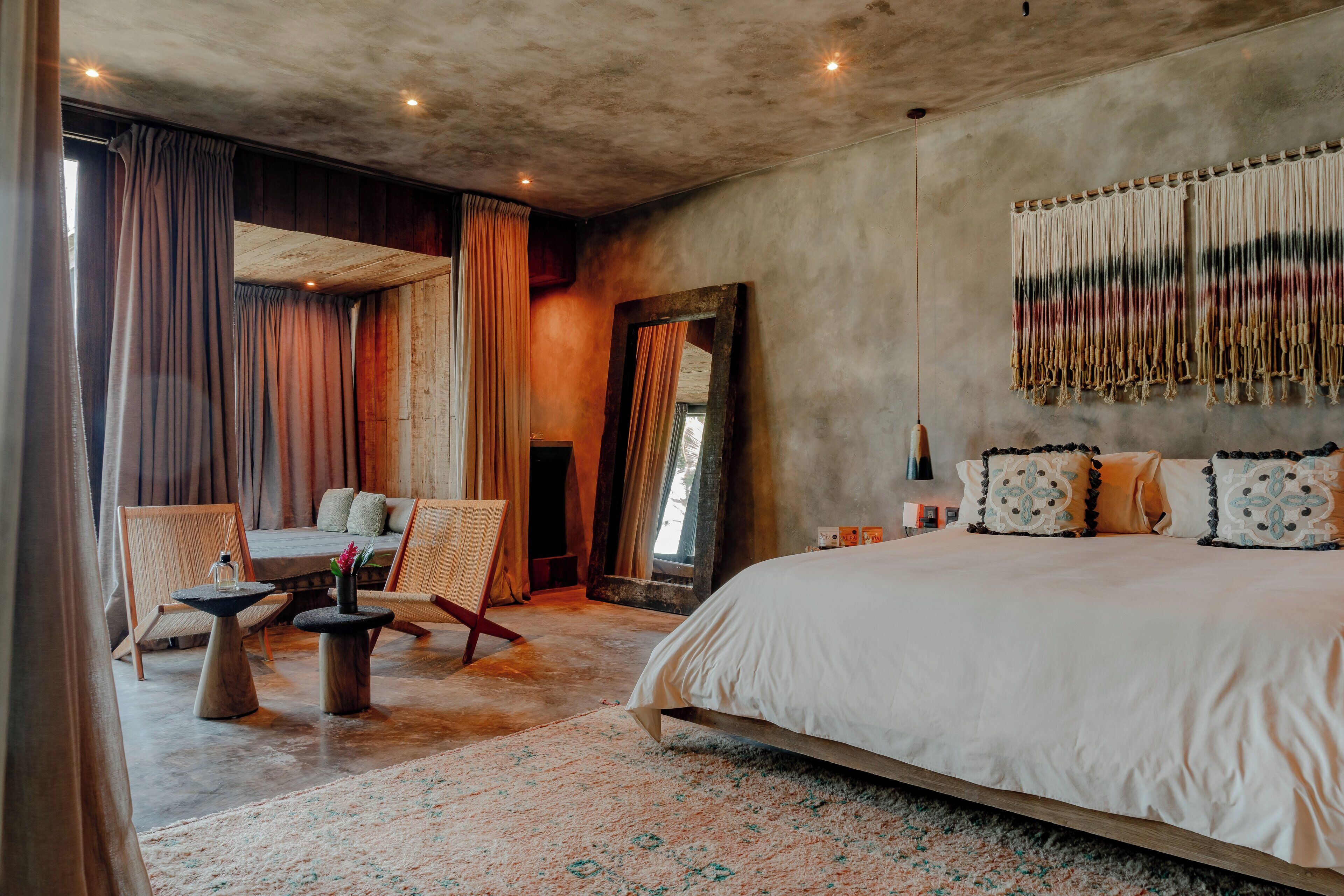 Une chambre à coucher avec un grand lit, une tête de lit en bois, un miroir et une décoration murale.