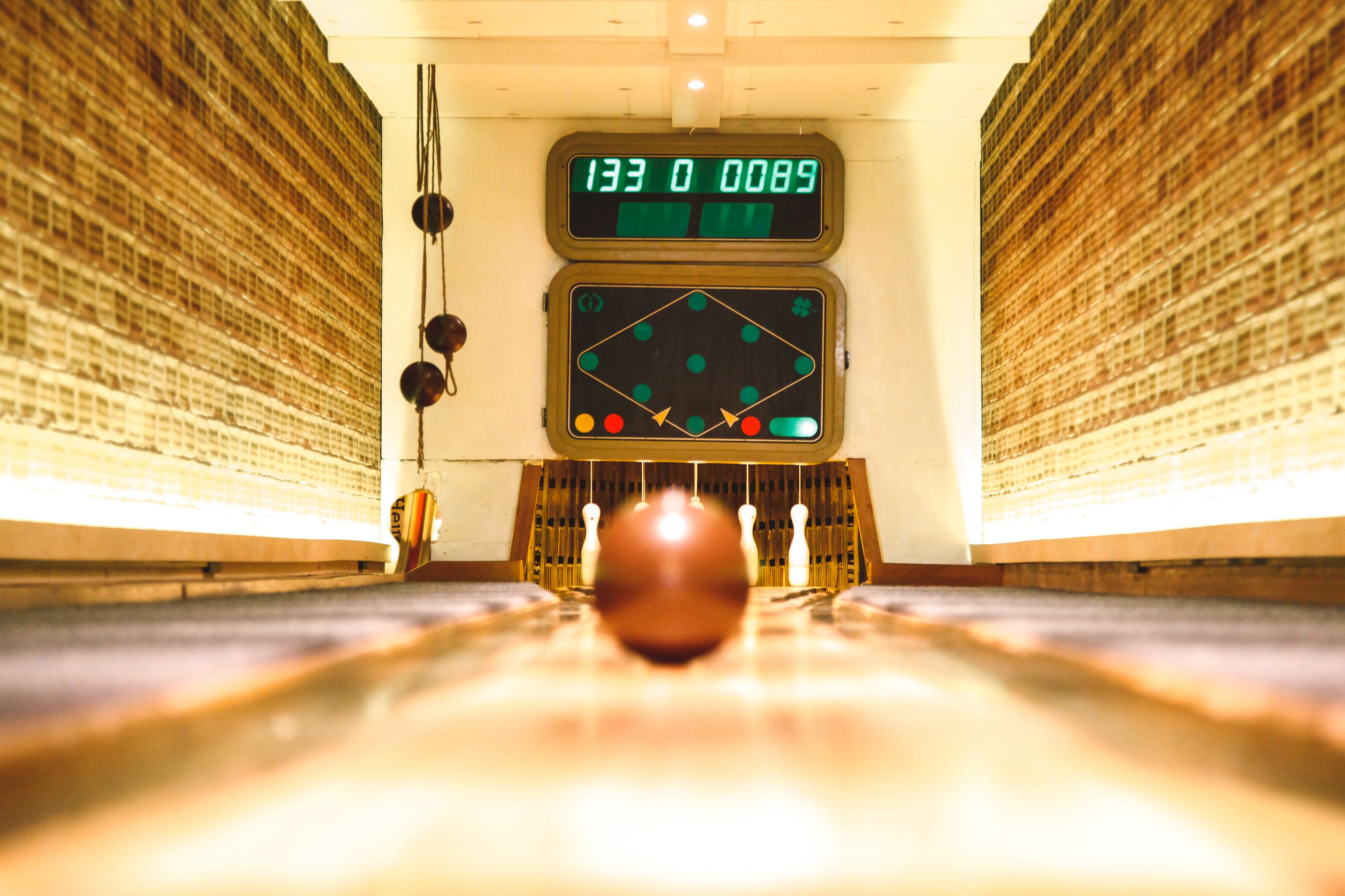 A bowling alley with a scoreboard displaying a score of 133-0.