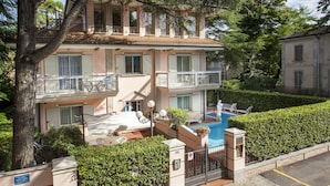 A two-story building with a swimming pool, outdoor seating, and a well-maintained garden. - Residence Villa Lidia (Riccione)