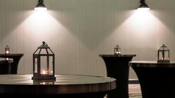 Varias mesas con lámparas de estilo farol en una habitación con poca luz.