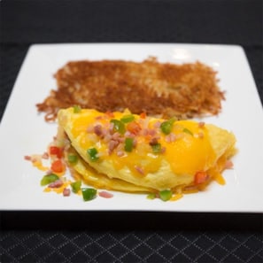 A plate with an omelette and hash browns. - Four Points By Sheraton Seattle Airport South (Des Moines)