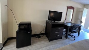 Un petit bureau équipé d’un bureau, d’une chaise et d’un four à micro-ondes.