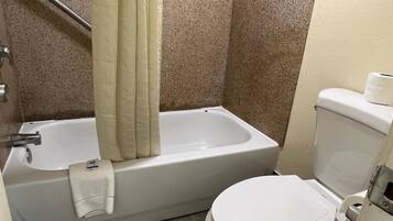 A bathroom with a bathtub, toilet, and shower curtain.