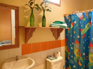 A bathroom with a sink, toilet, and shower curtain. - Valeri Emanuel Apartments (Bocas del Toro)