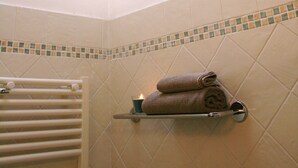 A skylight in a bathroom with a towel rack holding two towels and a candle. - Residenza Kenzia (Cattolica)