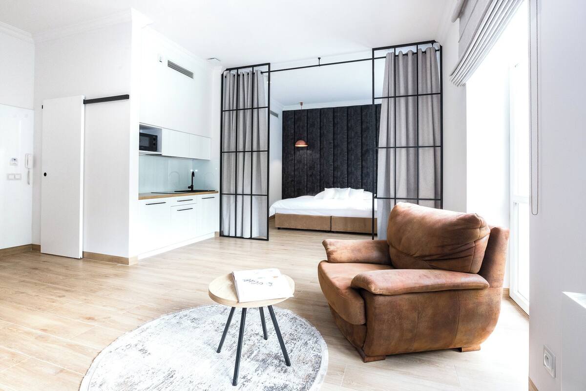 A modern bedroom with a bed, a sofa, and a small table.