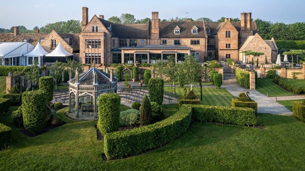 Un grand bâtiment historique, doté de nombreuses cheminées, d’un jardin magnifiquement entretenu et d’un belvédère.