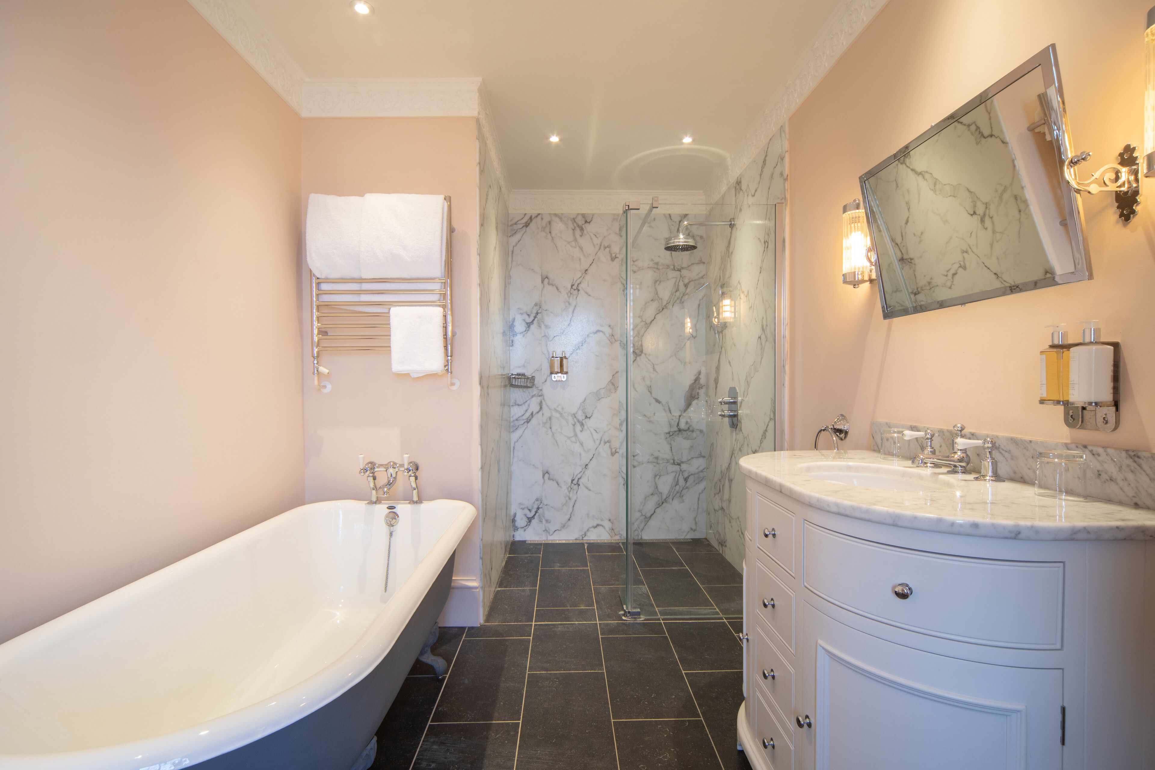 A bathroom with a freestanding bathtub, a glass-enclosed shower, and a vanity with a large mirror.