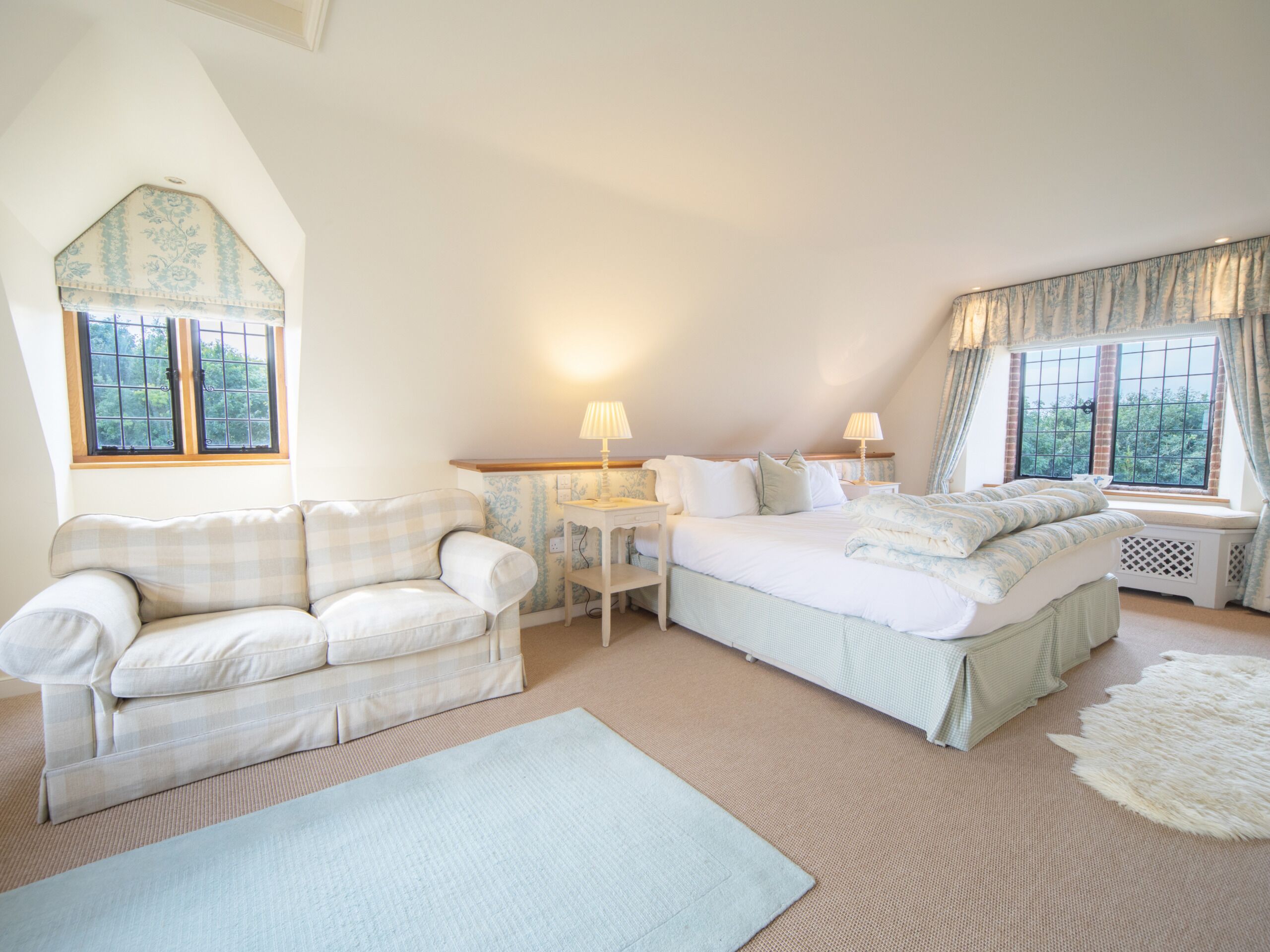 Une chambre confortable avec un lit, un canapé et une fenêtre.
