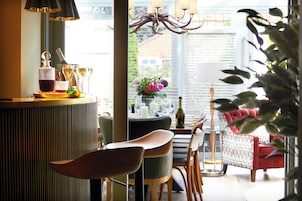 A modern interior with a bar area, seating, and a view through a large window.