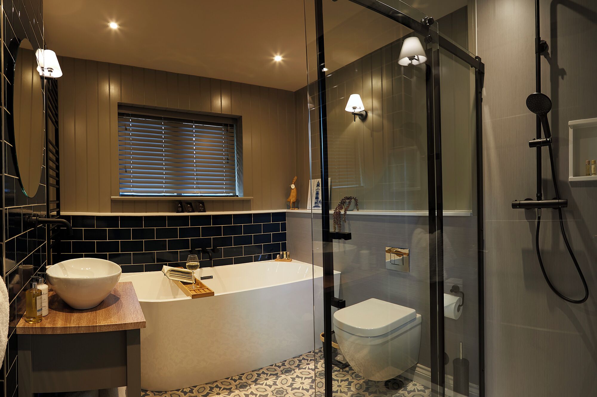 A modern bathroom with a freestanding bathtub, a toilet, and a glass-enclosed shower area.