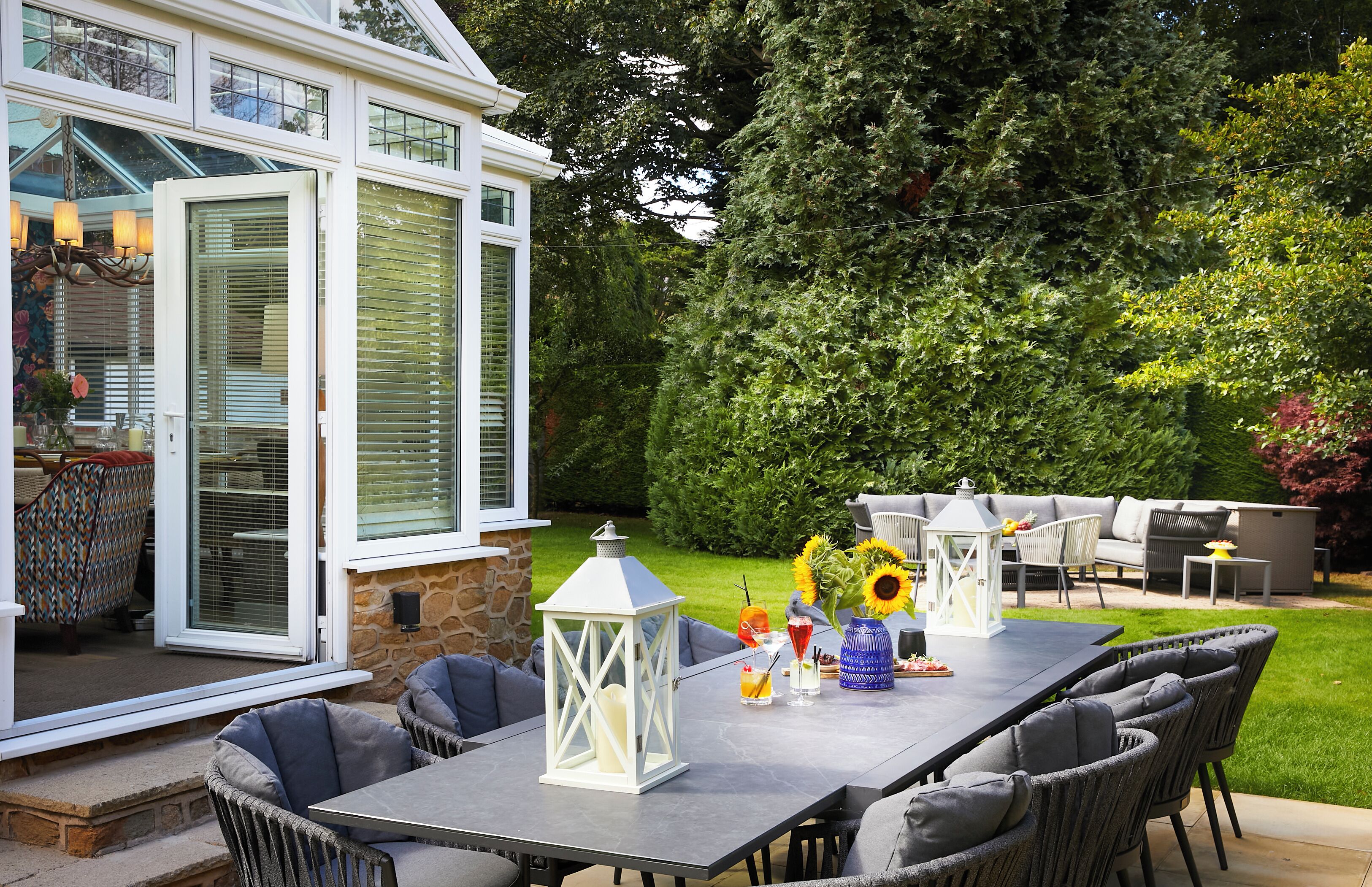 An outdoor patio with a dining table, chairs, and a decorative lantern.