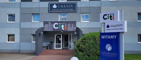 A hotel entrance with a sign for 'CITI' and 'WITAMY' indicating hotel group affiliation.