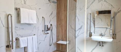 A modern bathroom with a glass-enclosed shower, marble walls, a wooden floor, a sink, and a mirror.