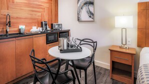 Cozinha compacta com mesa de jantar, cadeiras, cafeteira, torradeira e micro-ondas.