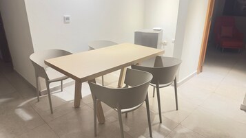 Un comedor con una mesa rectangular y cuatro sillas.
