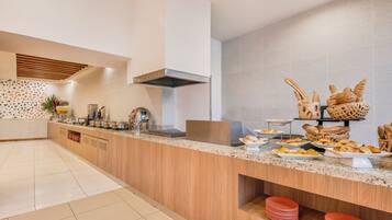 A modern kitchen with a wooden countertop, a built-in stove, and a variety of baked goods displayed on the counter.