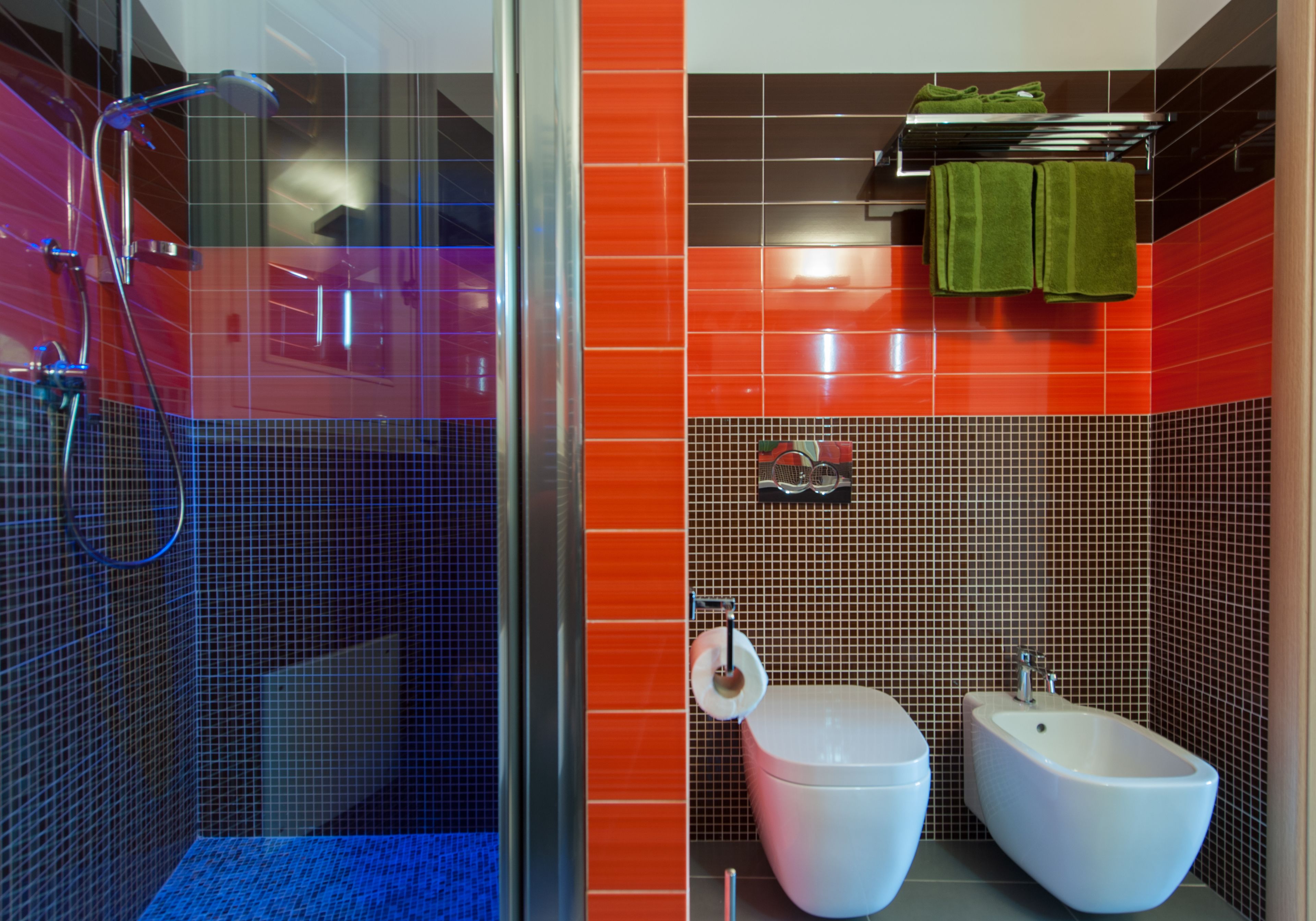 Un baño con ducha de vidrio, inodoro y bidé.