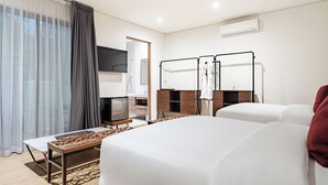 Een hotelkamer met een bed, een bureau, een televisie en een kledingkast.