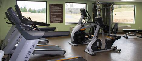 A gym with treadmills, elliptical machines, and weight equipment.