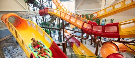 An indoor water park with multiple slides and a pool area.