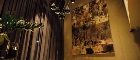 A modern living room with a sofa, a coffee table, and a large abstract painting on the wall.