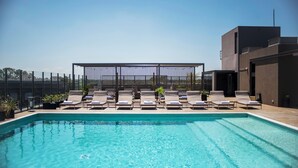 A swimming pool with lounge chairs and a pergola structure. - Kos Pilar Hotel (Villa Rosa)