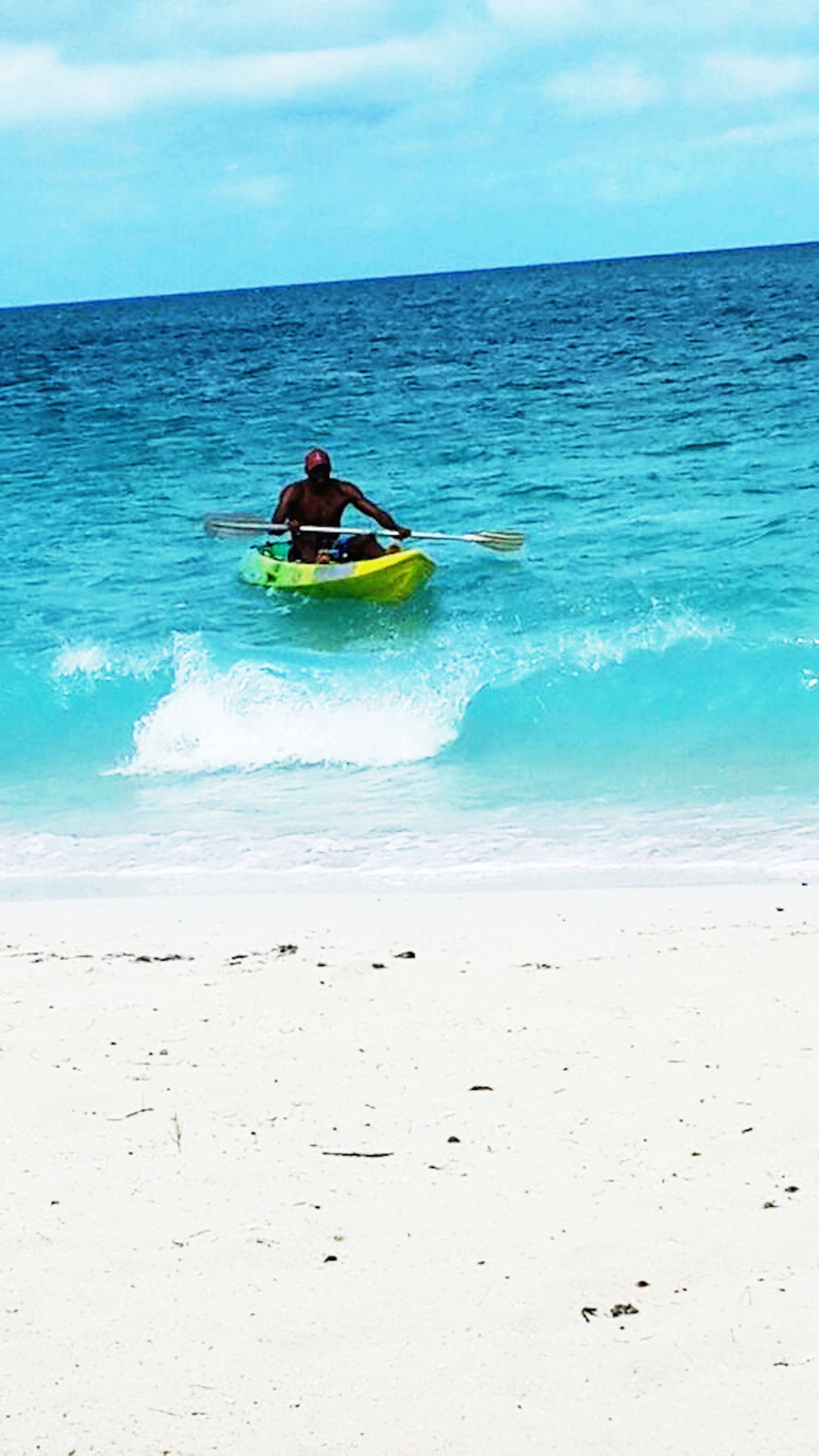 A person kayaking on a beach.