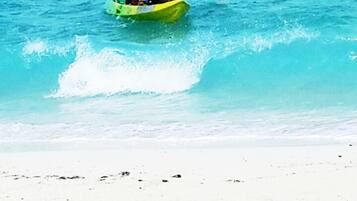 A person kayaking on a beach.