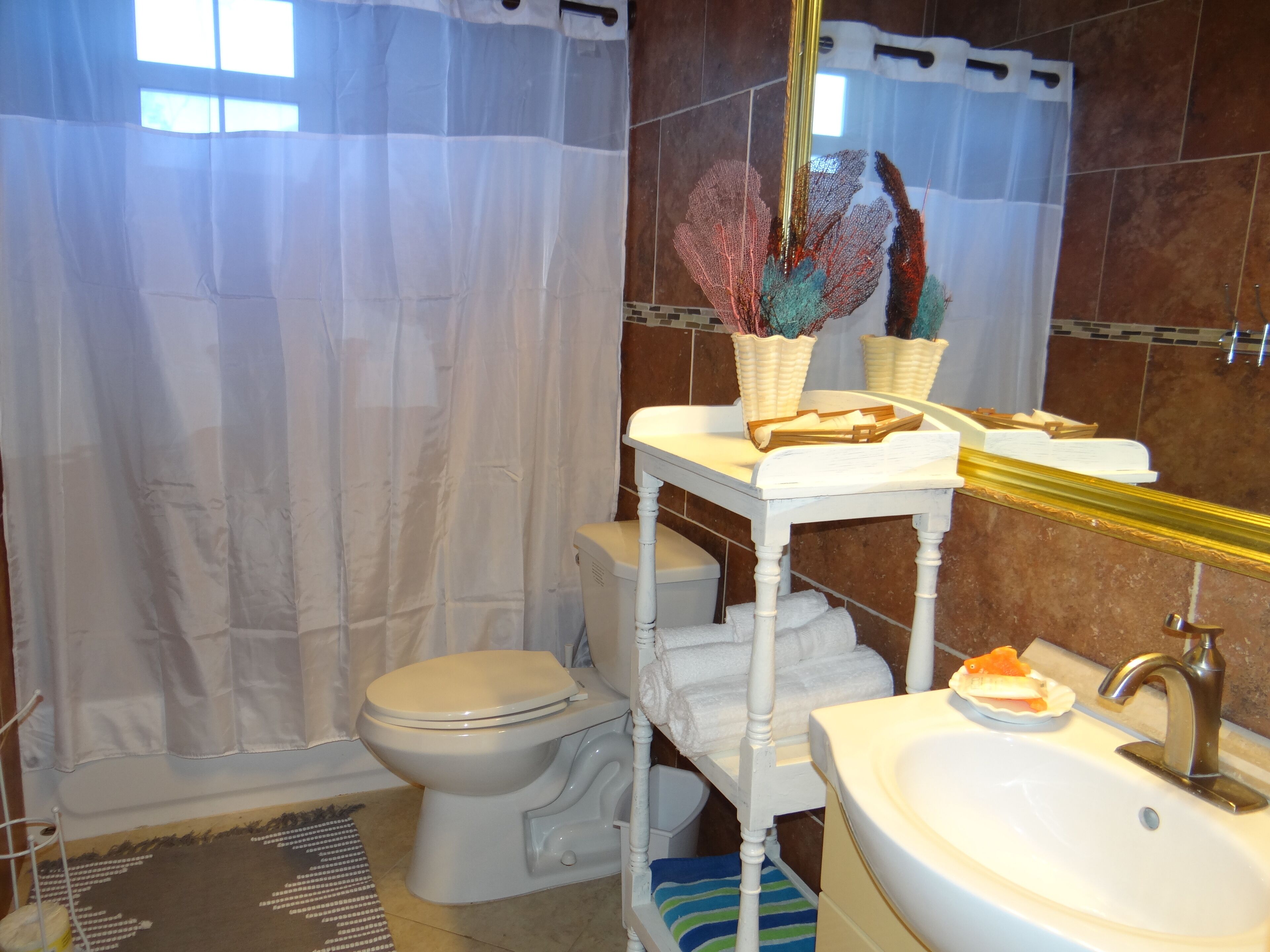 A bathroom with a toilet, sink, and shower curtain.