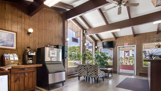 A restaurant with wooden walls, a bar area, and a seating section with patterned chairs.