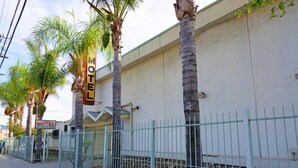 Un motel con un letrero, un área cercada y palmeras.