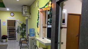A reception area with a bench, a water dispenser, and a clock on the wall. - Hotel Posada Los Olivos Los Mochis (Los Mochis)